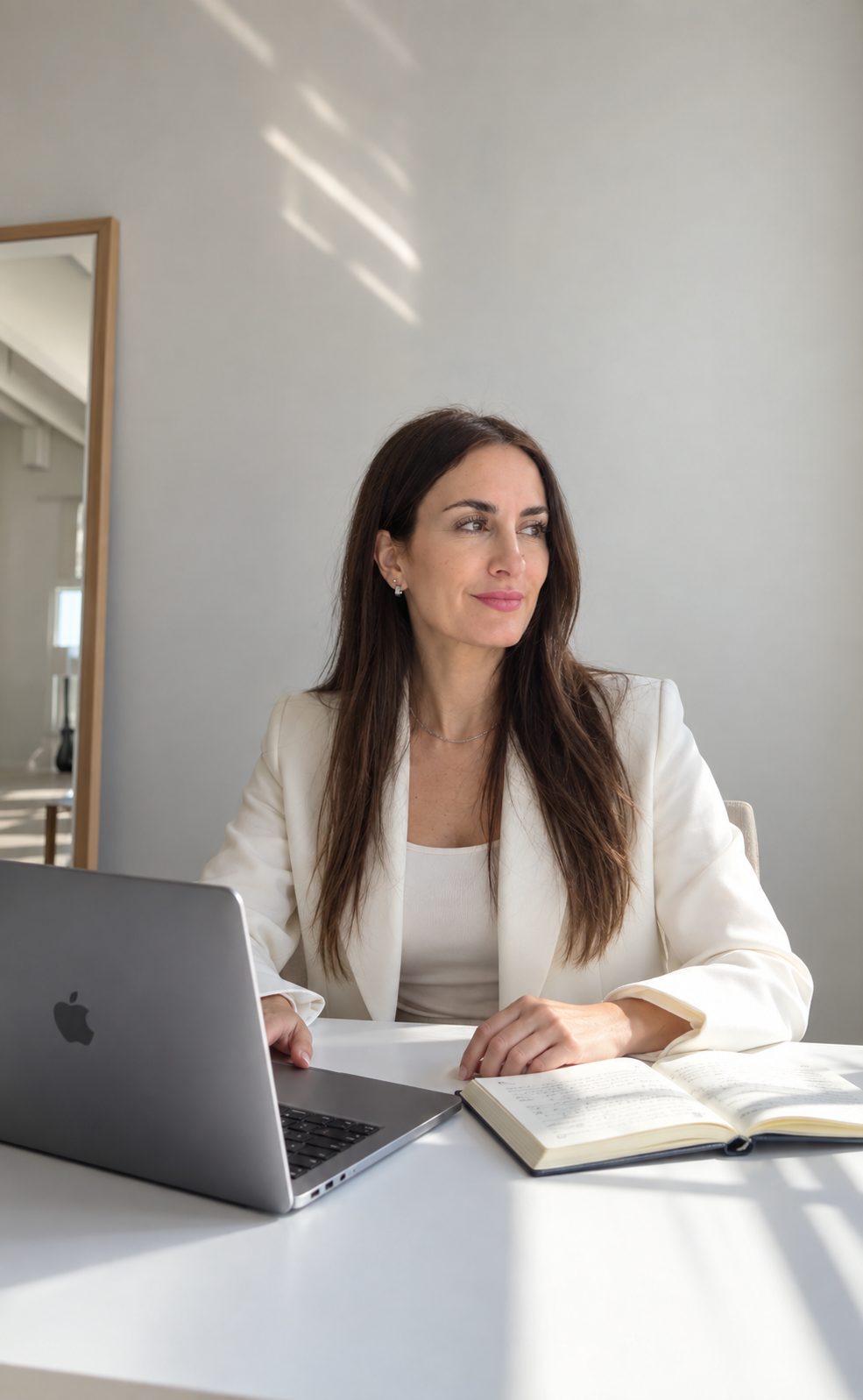 Vanina Sciarrone en su escritorio con un cuaderno abierto y una computadora portátil