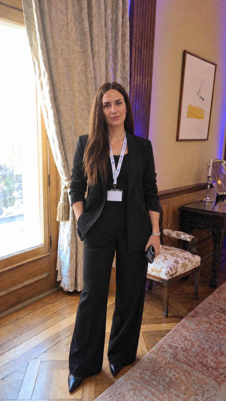 Vanina Sciarrone con credencial en un encuentro profesional, en un salón con cortinas y piso de madera